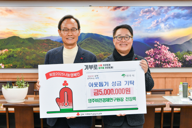 전창록(오른쪽) 영주비전경제연구원장이 박남서 영주시장에게 성금을 전달하고 있다. 영주시 제공