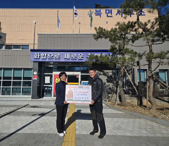 마라톤 시상금 100만원을 울진군 북면네에 기탁하고 있는 장성연(사진 오른쪽) 씨 .울진군 제공