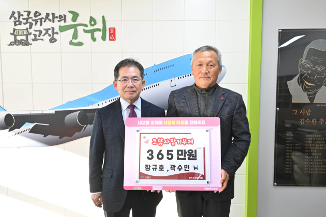 대구 군위군 우보면 장규호(오른쪽) 형재건설 대표가 장규호·곽수민 예비부부를 대신해 군위군에 고향사랑기부금을 기탁하고, 김진열(왼쪽) 군수와 기념 사진을 촬영하고 있다. 군위군 제공
