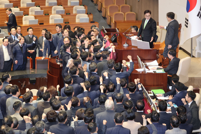 우원식 국회의장이 27일 오후 국회 본회의에서 한덕수 국무총리 탄핵소추안 가결 의결정족수에 대한 설명(재적의원 과반수 찬성)을 하자, 국민의힘 권성동 대표 권한대행 겸 원내대표가 의장석에 올라가 항의하고 있다. 연합뉴스