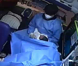 간호사 출신인 청송소방서 소속 김기현 소방사가 30일 구급차 안에서 출산한 아이를 안고 병원으로 이동하는 모습. 청송소방서 제공