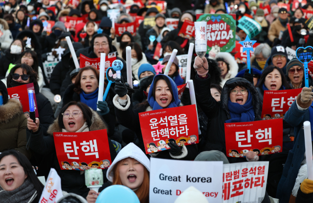 윤석열 대통령 탄핵소추안이 가결된 14일 서울 여의도 국회 앞에서 열린 탄핵 촉구 집회에 참석한 시민들이 탄핵이 가결되자 환호하고 있다. 연합뉴스