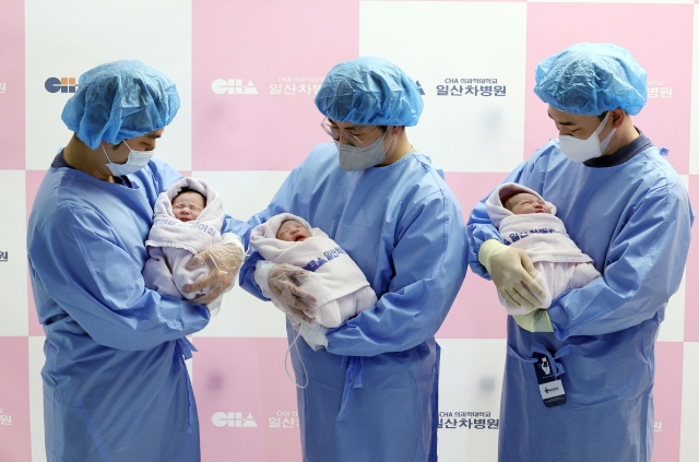 새해 첫날인 1일 0시 경기 고양시 일산차병원에서 엄마 이승현 씨와 아빠 박준수 씨 사이에서 태어난 태명 니케(왼쪽부터), 엄마 구라겸 씨와 아빠 이효영 씨 사이에서 태어난 꼬물이, 엄마 구슬기 씨와 아빠 강우석 씨 사이에서 태어난 딩굴이가 아빠 품에 안겨 있다. 연합뉴스