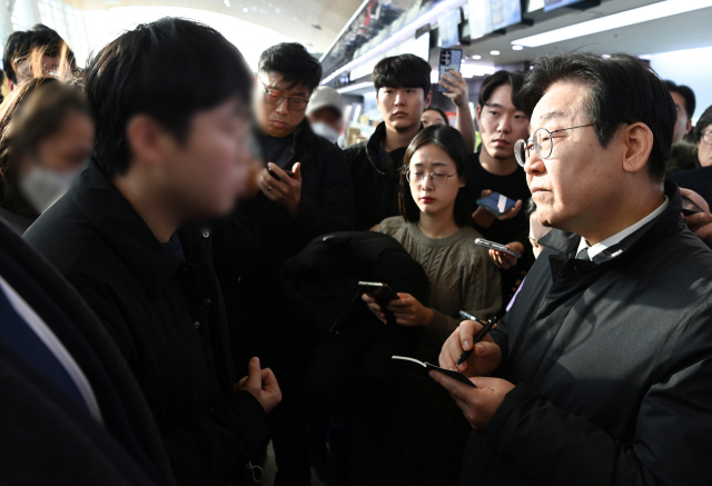 더불어민주당 이재명 대표가 31일 전남 무안국제공항 터미널에서 제주항공 여객기 참사 유가족을 위로하며 요구사항을 메모하고 있다. 연합뉴스
