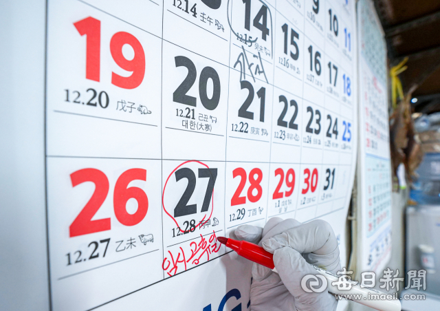 정부가 1월 27일을 임시공휴일을 지정하면서 최대 9일의 설 황금연휴가 현실화된 8일 대구 중구 서문시장에서 한 상인이 달력에 빨간펜으로 임시공휴일을 표시하고 있다. 매일신문DB