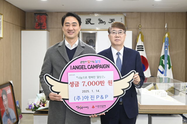 (주)아진P&P 정연수(오른쪽) 부회장이 지난 1월 14일 최재훈 달성군수에게 이웃돕기 성금을 기탁하고 있다. 달성군 제공.