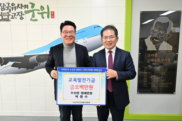 대구 군위군 박창수(왼쪽) 우보면 명예면장이 군위군에 교육발전기금을 기탁하고, 김진열(오른쪽) 군수와 기념 사진을 촬영하고 있다. 군위군 제공