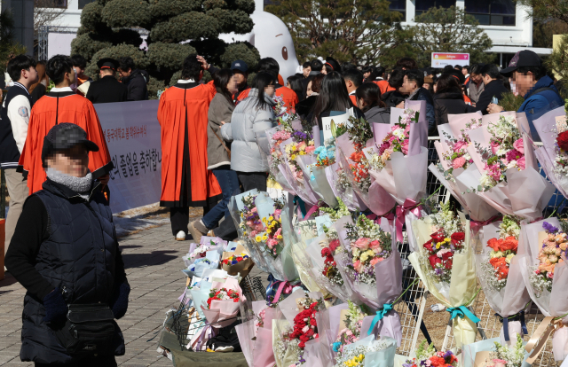 13일 서울 장충동 동국대학교에서 열린 학위수여식에서 꽃 판매 상인이 고객을 기다리고 있다. 경기 악화 속 소비 심리가 위축되면서 졸업식 시즌이지만 꽃다발 특수도 사라졌다. 연합뉴스