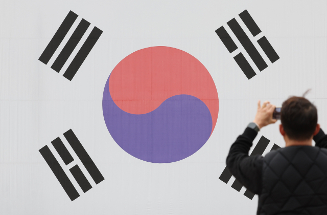 3·1절을 하루 앞둔 28일 서울 서대문구 서대문형무소에서 한 관람객이 대형 태극기 앞에서 기념 촬영을 하고 있다. 연합뉴스
