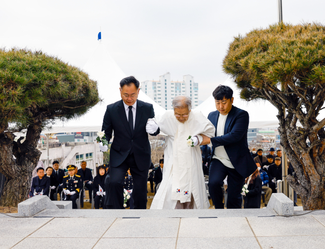 장진홍 의사의 손자 장상규(중앙)씨가 김재욱 칠곡군수의 부축을 받으며 헌화대로 오르고 있다. 칠곡군 제공