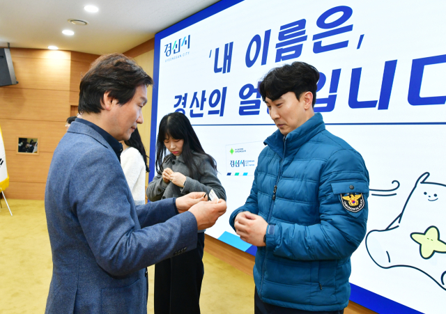 조현일 경산시장(좌측)이 직원들에게 명찰을 달아 주고 있다. 경산시 제공