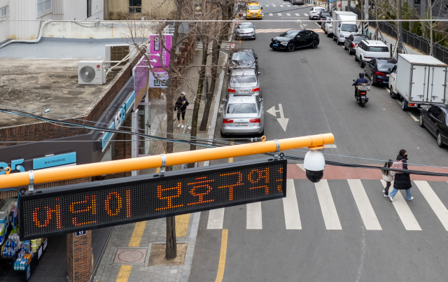 6일 대구 동구 한 초등학교 앞 어린이보호구역에 설치된 불법주정차 단속 카메라 아래로 어린이와 보호자가 길을 건너고 있다. 대구시는 이달 말까지 스쿨존 불법주정차 집중단속에 나설 예정이다. 김영진 기자 kyjmaeil@imaeil.com