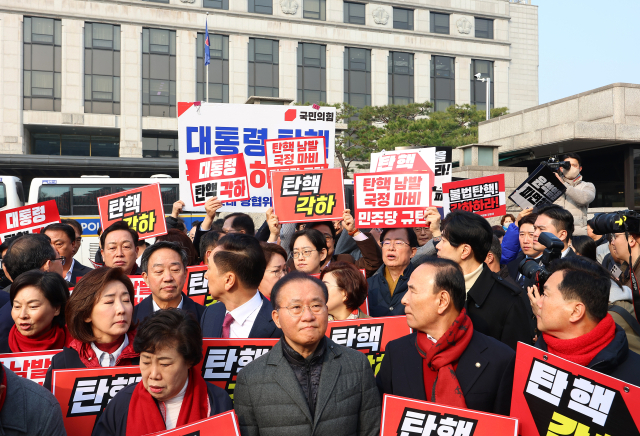21일 서울 종로구 헌법재판소 앞에서 윤석열 대통령 탄핵 각하 촉구 기자회견을 준비하던 국민의힘 의원들(앞쪽)이 윤 대통령 즉각 파면 촉구 기자회견을 하는 더불어민주당 의원들(뒤쪽)을 바라보고 있다. 연합뉴스