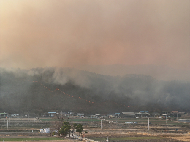 22일 경북 의성군 안평면 괴산리 야산에서 발생한 산불이 의성읍 원당2리 마을 인근까지 번지자 산불진화 헬기가 진화작업을 벌이고 있다. 김영진 기자 kyjmaeil@imaeil.com