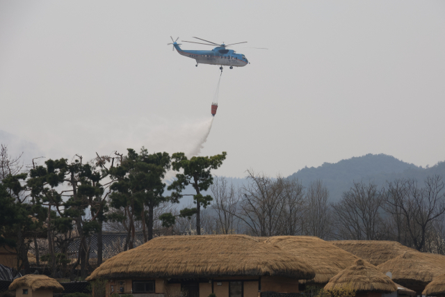 경북북부 산불이 엿새째 꺼지지 않고 있는 27일 안동 하회마을에 헬기가 물을 뿌리고 있다. 연합뉴스