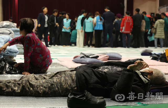이재명 더불어민주당 대표가 27일 영양군민회관에 마련된 산불 피해 관련 대피소를 방문한 가운데 터전을 잃은 이재민들이 바닥에 누워 휴식을 취하고 있다. 안성완 기자. asw0727@imaeil.com