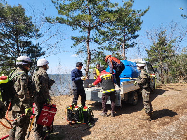 30일 경북 영양군 노달리 인근의 한 산 정상 부근에서 군장병과 산불진화대원 등이 잔불 진화작업에 나섰다. 이영광 기자