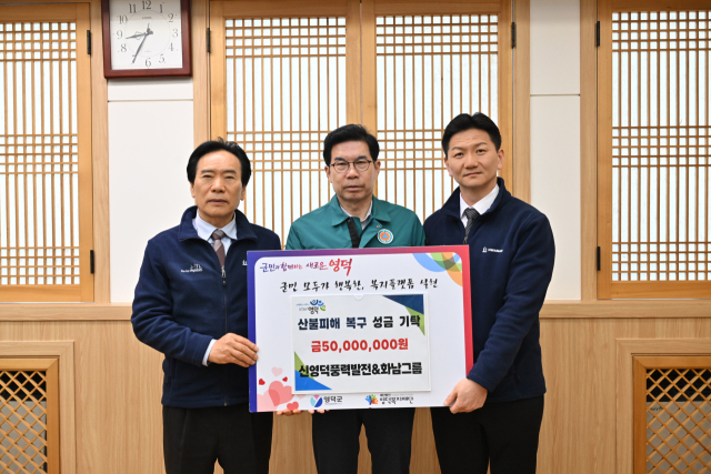 신영덕풍력발전·화남그룹 박몽용 대표(왼쪽)가 김광열 영덕군수에게 산불피해 복구를 위한 성금 5천만원을 전달하고 있다. 영덕군 제공