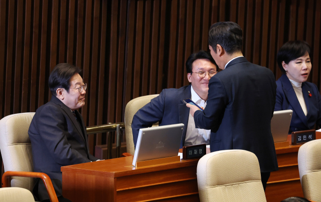 더불어민주당 이재명 대표(왼쪽)와 정청래, 김민석 의원이 2일 서울 여의도 국회에서 열린 본회의에서 스마트폰을 보며 대화하고 있다. 연합뉴스