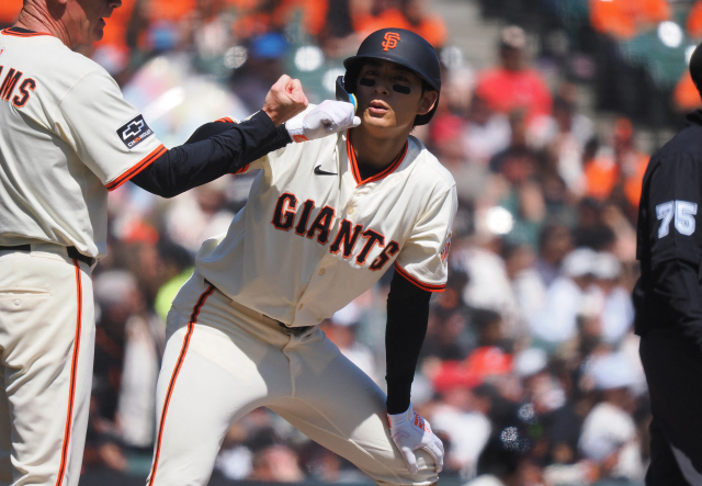 샌프란시스코 자이언츠의 이정후가 10일 미국 샌프란시스코에서 열린 MLB 신시내티 레즈와의 경기 도중 3루타를 친 뒤 3루 베이스에서 코치 매트 윌리엄스의 환영을 받고 있다. 연합뉴스