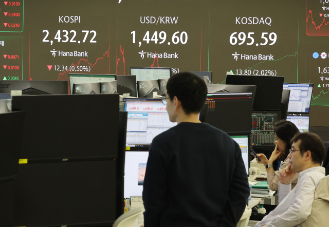 11일 서울 중구 하나은행 본점 딜링룸에서 딜러들이 대화하고 있다. 이날 코스피는 전 거래일 대비 12.34포인트(0.50%) 내린 2,432.72에 거래를 마쳤다. 원/달러 환율은 6.5원 내린 1,449.9원. 연합뉴스