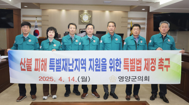 지난 14일 영양군의회가 제1회 추가경정예산안을 처리한 뒤 산불 피해 특별재난지역 지원을 위한 특별법 제정 촉구 현수막을 들고 촬영하고 있다. 영양군의회 제공
