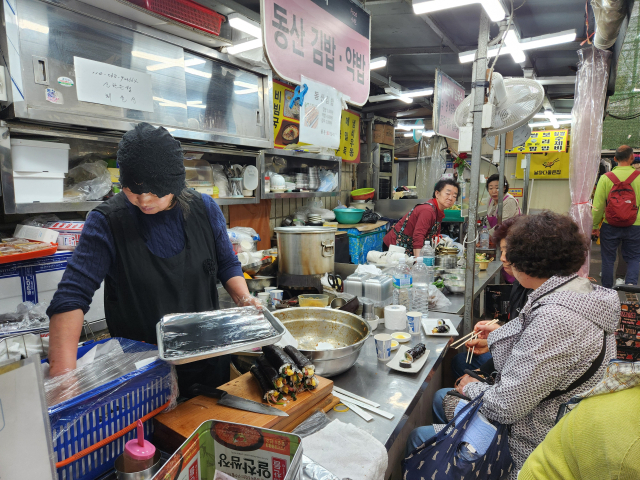 16일 대구 대표 전통시장 서문시장 한 김밥집에서 음식을 준비하는 식당 주인 앞에서 손님들이 김밥을 먹고 있다. 이통원 기자 tong@imaeil.com