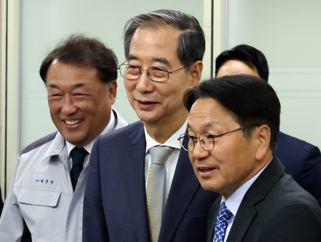 한덕수 대통령 권한대행 국무총리가 15일 기아 오토랜드 광주공장에서 자동차산업 현장 간담회장으로 이동하고 있다. 왼쪽부터 최준영 기아 사장, 한 권한대행, 강기정 광주시장. 연합뉴스
