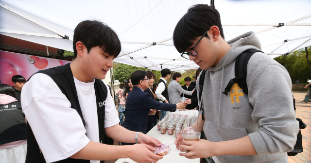 대구가톨릭대 성한기 총장과 총학생회가 16일 본교 중앙도서관 앞 광장에서 시험기간을 맞이한 재학생들에게 식혜 슬러시와 초콜릿 쌀 도넛을 배부했다. 대구가톨릭대 제공