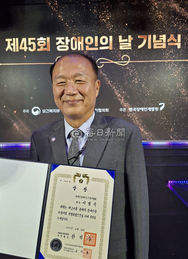 이범식 씨가 18일 제45회 장애인의 날 기념식에서 올해의 장애인 상을 수상한 후 기념사진을 찍고 있다. 김진만 기자