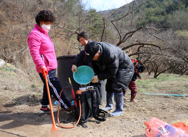지난달 29일 의성군 사곡면 신감리 한 야산에서 연기가 확산하자 불을 끄러 온 주민들이 잔불 진화용수를 챙기고 있다. 연합뉴스
