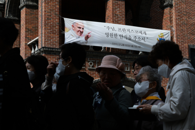 23일 서울 중구 명동대성당 지하성당에 마련된 프란치스코 교황 빈소를 찾은 추모객들이 조문하기 위해 줄을 서고 있다. 연합뉴스