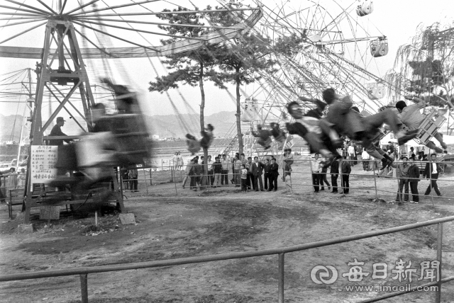 1960년대 동촌 유원지에서 양복 차림의 어른들이 회전그네를 타고 있다. 이 회전그네는 1963년 5월 29일 유기장 허가를 받고 운영에 들어갔다. 사진=매일아카이빙센터