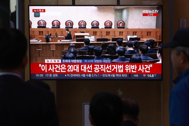 1일 서울역에서 시민들이 더불어민주당 이재명 대선 후보 공직선거법 사건에 대한 대법원 판결 생중계를 보고 있다. 연합뉴스