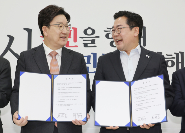 1일 서울 여의도 국회에서 더불어민주당 박찬대 당대표 직무대행 겸 원내대표(오른쪽)와 국민의힘 권성동 원내대표가 추경안 합의문에 서명한 뒤 미소짓고 있다. 연합뉴스