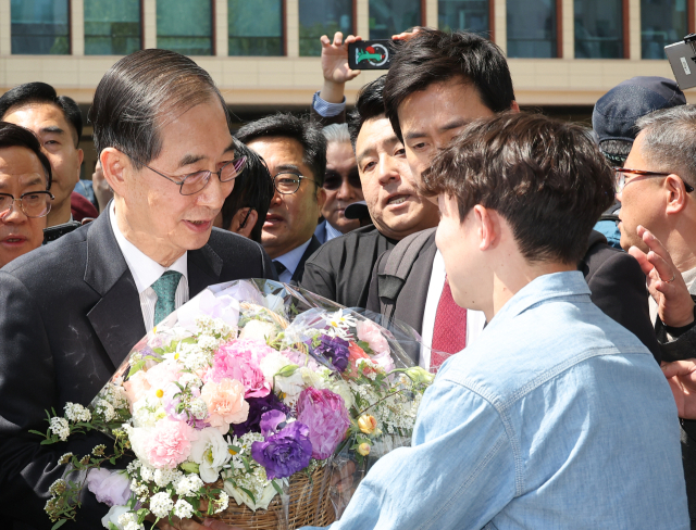 한덕수 전 국무총리가 2일 서울 여의도 국회 소통관에서 대통령 선거 출마 선언을 마치고 나와 지지자로부터 꽃바구니를 받고 있다. 연합뉴스
