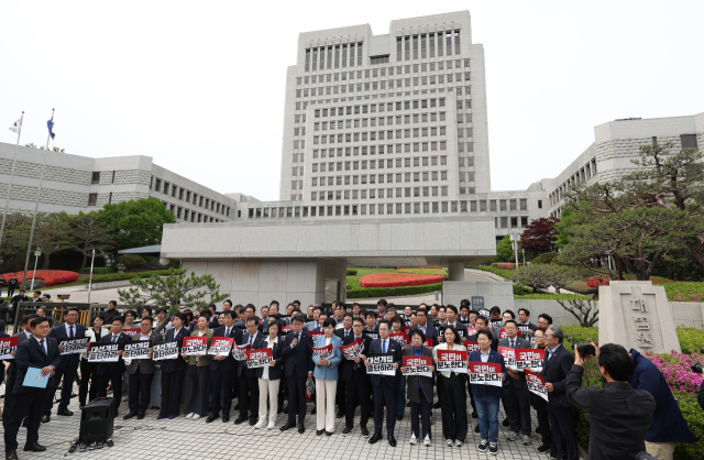 더불어민주당 의원들이 2일 서울 서초구 대법원 앞에서 열린 기자회견에서 이재명 대선 후보의 공직선거법 위반 사건 상고심 결과를 규탄하는 손팻말을 들고 있다. 연합뉴스