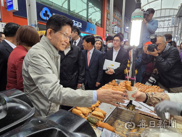 6일 포항 죽도시장을 찾은 김문수 국민의힘 대선후보가 한 상인으로부터 즉석어묵꼬치를 건네받고 있다. 신동우 기자