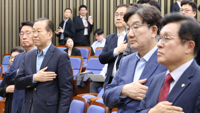 국민의힘 권영세 비상대책위원장과 권성동 원내대표 등이 6일 서울 여의도 국회에서 열린 의원총회에서 국기에 경례하고 있다. 연합뉴스
