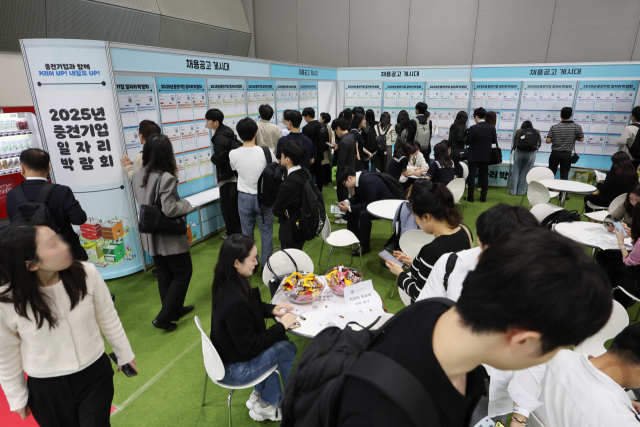 21일 서울 강남구 코엑스에서 열린 2025 중견기업 일자리 박람회를 찾은 구직자들이 채용공고 게시물을 보고 있다. 연합뉴스