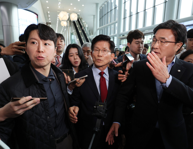 국민의힘 김문수 대선 후보가 6일 아시아태평양경제협력체(APEC) 회의장인 경북 경주시 경주화백컨벤션센터에서 후보 일정을 중단하고 서울로 올라가 현안 문제에 대한 대책을 마련하겠다고 밝힌 뒤 취재진에 둘러싸여 있다. 오른쪽은 초선·재선 대표인 김대식 의원. 연합뉴스