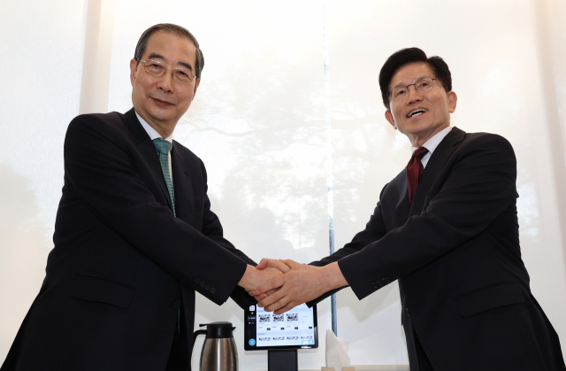 국민의힘 김문수 대선후보와 무소속 한덕수 대선 예비후보가 7일 서울 종로구의 한 식당에서 후보 단일화 관련 회동을 하기 전 악수하고 있다. 연합뉴스