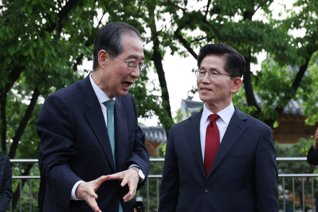 국민의힘 김문수 대선후보와 무소속 한덕수 대선 예비후보가 8일 서울 국회 사랑재에 위치한 커피숍에서 회동을 마친 후 인사하고 있다. 연합뉴스
