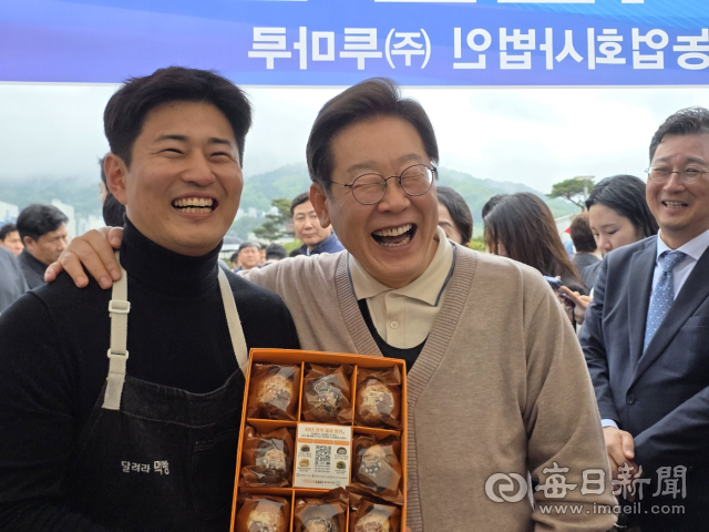 이재명 더불어민주당 대선후보가 경북도민체전 지역특산물홍보부스에서 상인과 함께 함박웃음을 짓고 있다. 신현일 기자