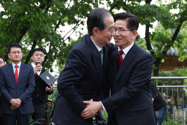 국민의힘 김문수 대선후보와 무소속 한덕수 대선 예비후보가 지난 8일 서울 국회 사랑재에 위치한 커피숍에서 회동을 마친 후 포옹하고 있다. 연합뉴스