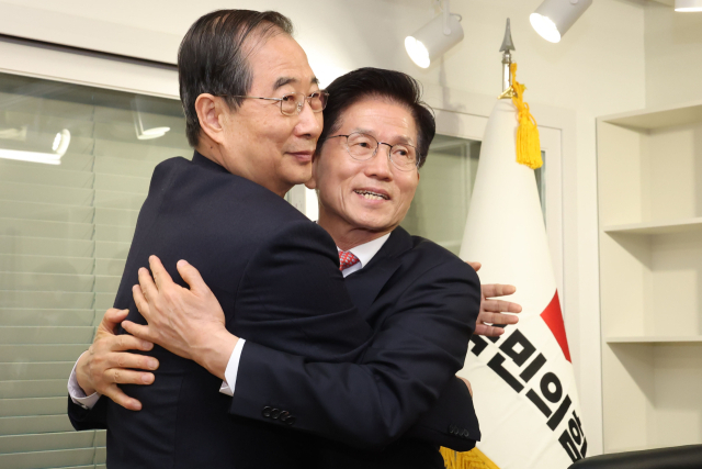 국민의힘 김문수 대선 후보와 한덕수 전 국무총리가 11일 국민의힘 당사에서 만나 포옹하고 있다. 연합뉴스