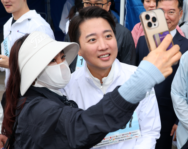 개혁신당 이준석 대선 후보가 11일 오전 부산 해운대구 벡스코 일대에서 열린 다이아몬드브릿지 걷기축제에 참가해 시민들과 사진을 찍고 있다. 연합뉴스