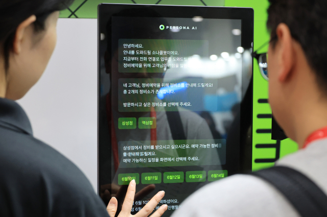 14일 서울 강남구 코엑스에서 열린 2025 국제인공지능대전에서 관계자가 대화형 AI로봇과 대화하고 있다. 연합뉴스