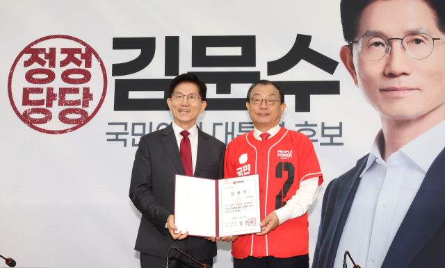 국민의힘 김문수 대선 후보(왼쪽)가 15일 국회에서 열린 중앙선거대책위원회 회의 및 임명장 수여식에서 이정현 공동선대위원장에게 임명장을 전달한 뒤 기념 사진을 촬영하고 있다. 연합뉴스