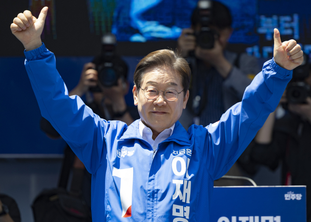 더불어민주당 이재명 대선후보가 14일 부산 부산진구 서면에서 열린 유세에 도착해 단상에 오른 뒤 엄지를 들어 보이며 인사하고 있다. 연합뉴스